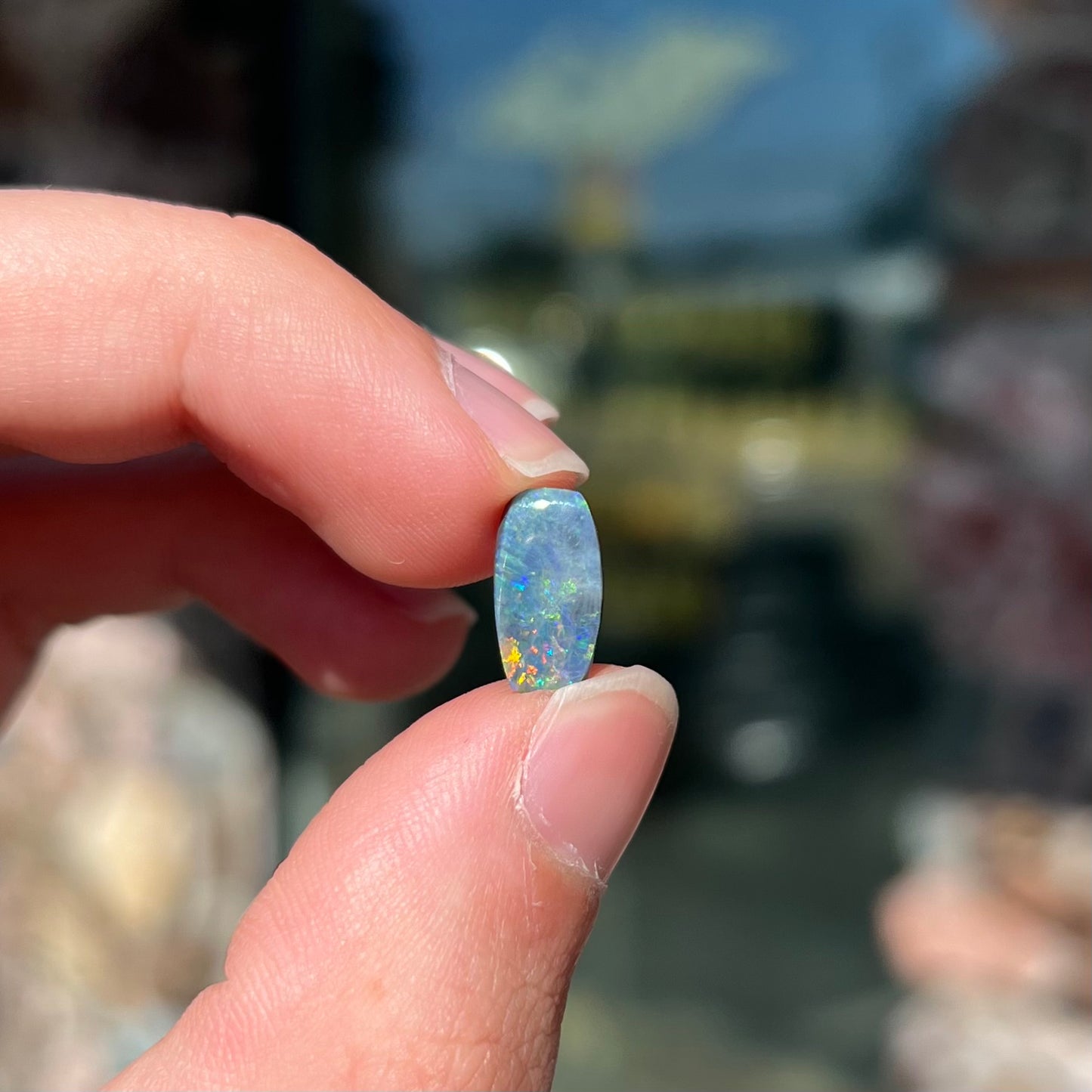A loose 1.76ct barrel shaped black opal stone from Lightning Ridge, Australia. The opal has a rainbow of colors.