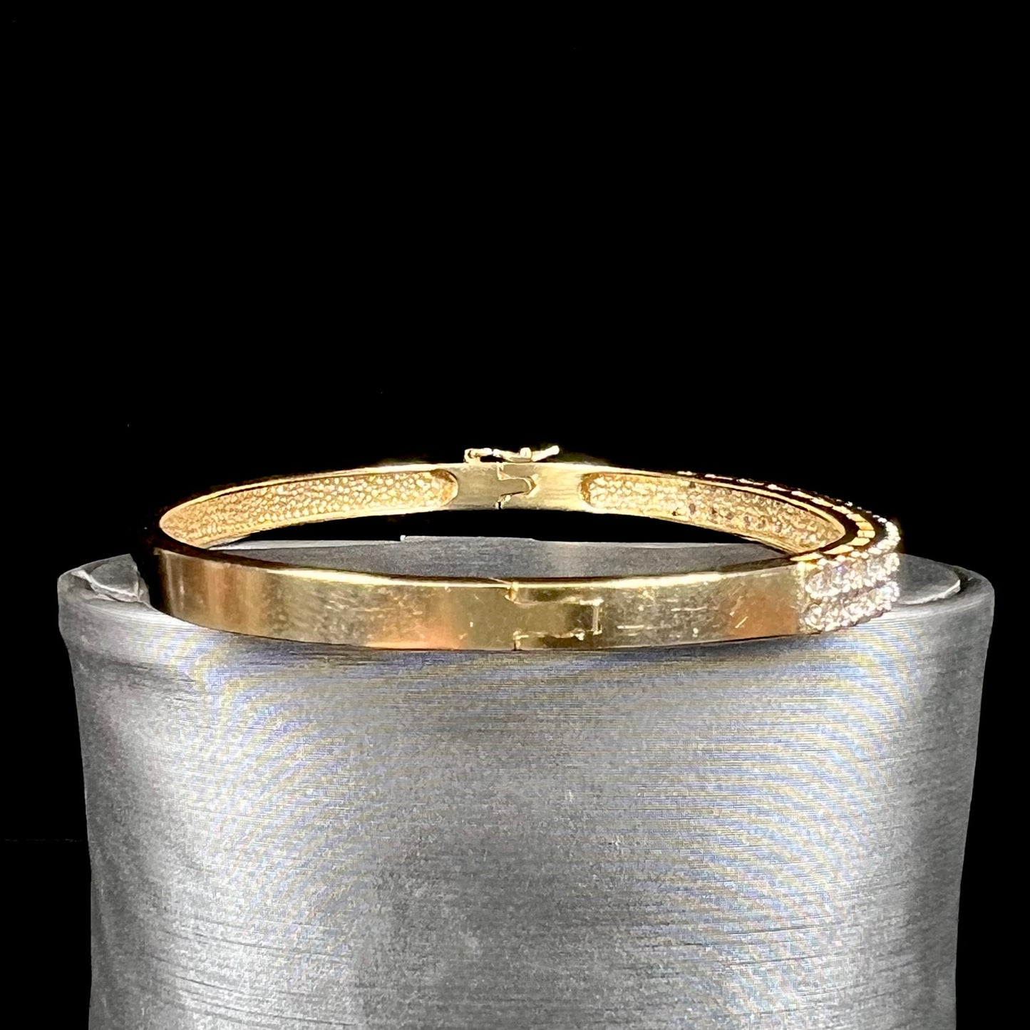 A ladies' hinged yellow gold bangle bracelet set with 50 Standard Round Brilliant Cut diamonds.