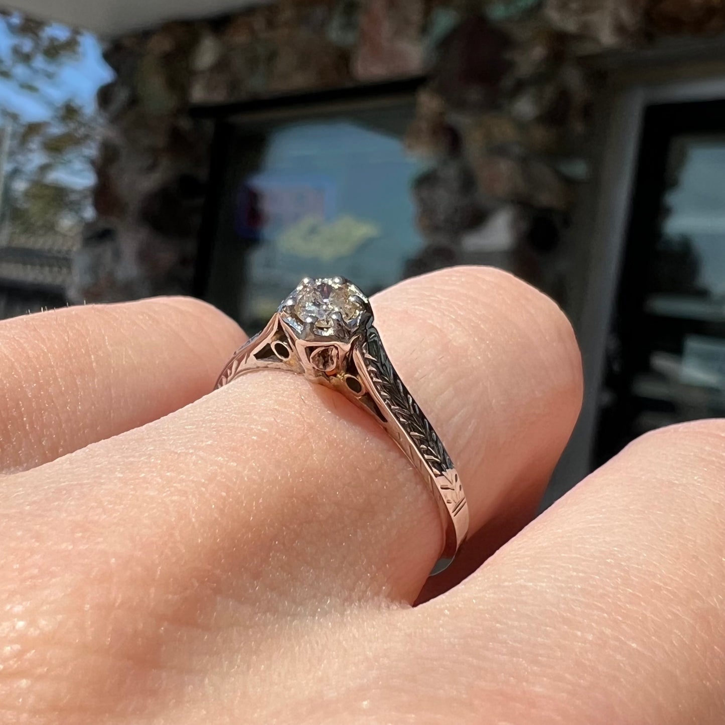 An Art Deco style 18 karat white gold diamond solitaire ring. The ring has scroll work on the side of the shank.