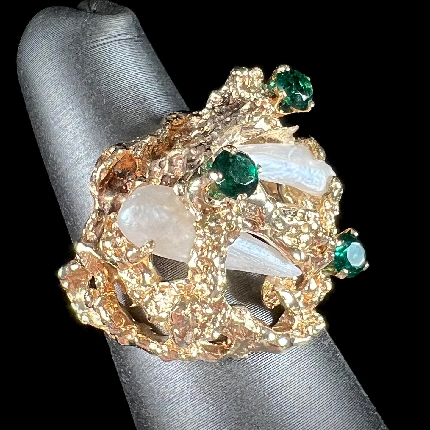 A vintage 1950's gold cluster ring set with freshwater pearls and green imitation emeralds.