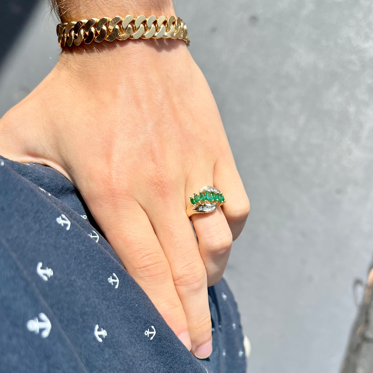 A vintage, 1970's style yellow gold ring set with marquise cut emeralds and round brilliant cut diamonds.