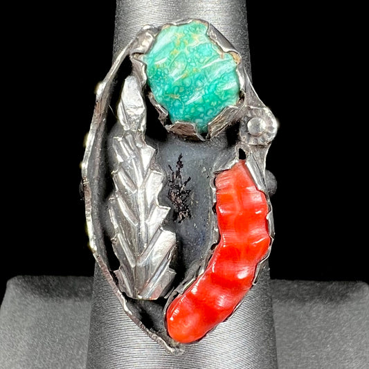 A ladies' vintage Southwest silver ring set with carved Royston turquoise and coral stones.