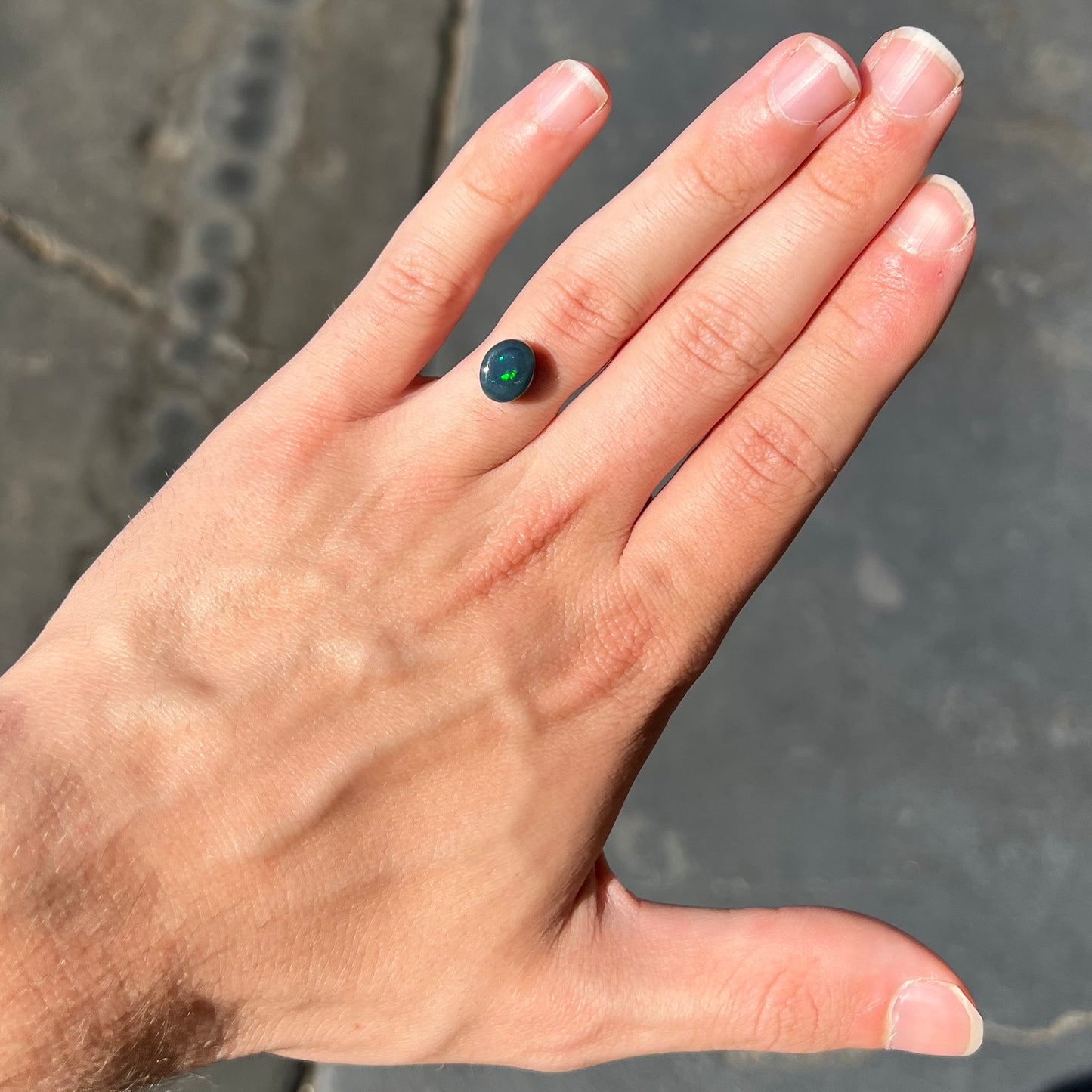 A 2.68 carat loose, oval cabochon cut black opal stone from Lightning Ridge, Australia. The opal has a N2 body tone.