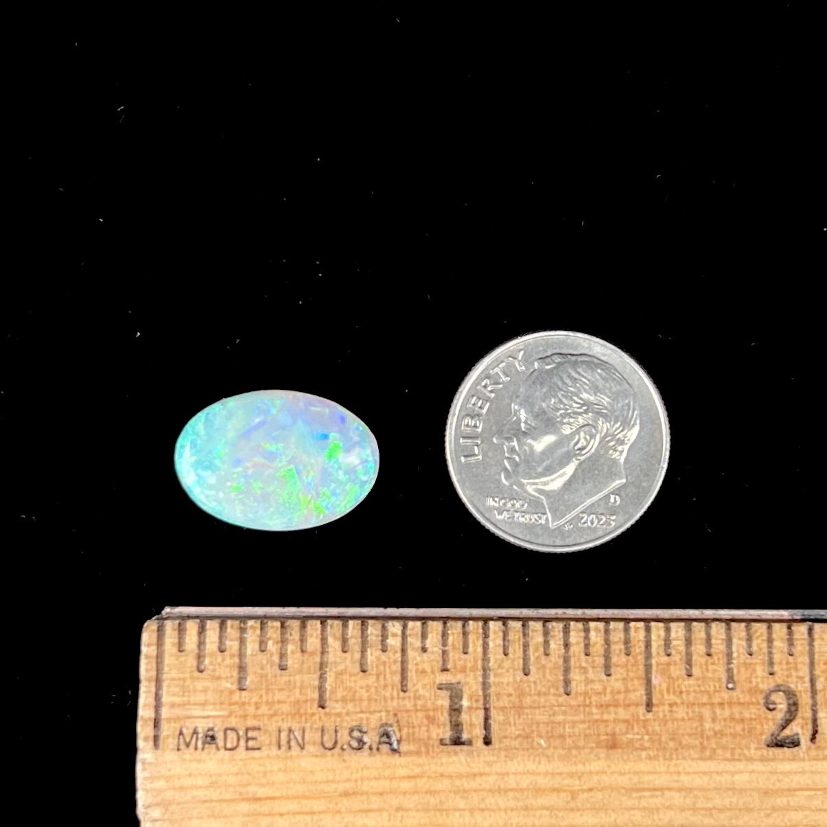 A double-sided opal stone from Coober Pedy, Australia. The opal plays green, blue, and orange colors from the front and the back.