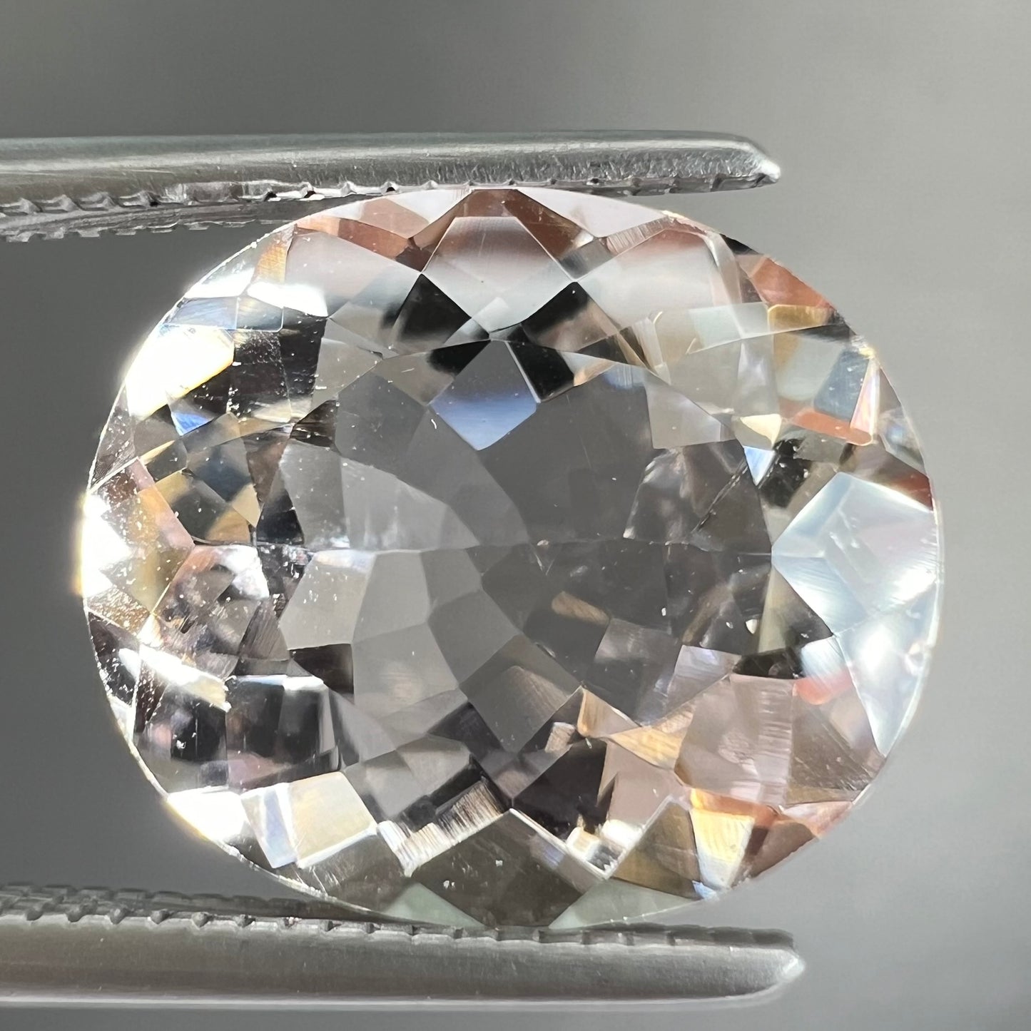 A loose, faceted oval cut pink morganite gemstone.