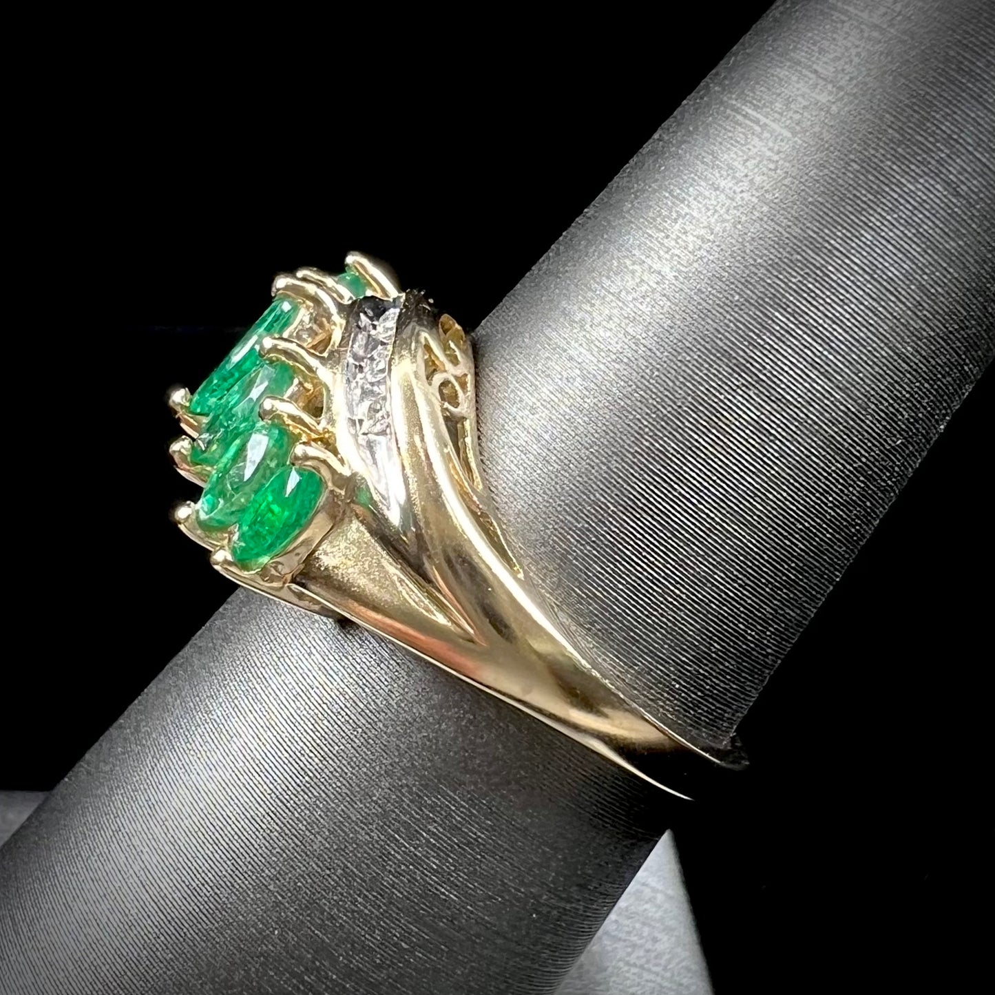 A vintage, 1970's style yellow gold ring set with marquise cut emeralds and round brilliant cut diamonds.