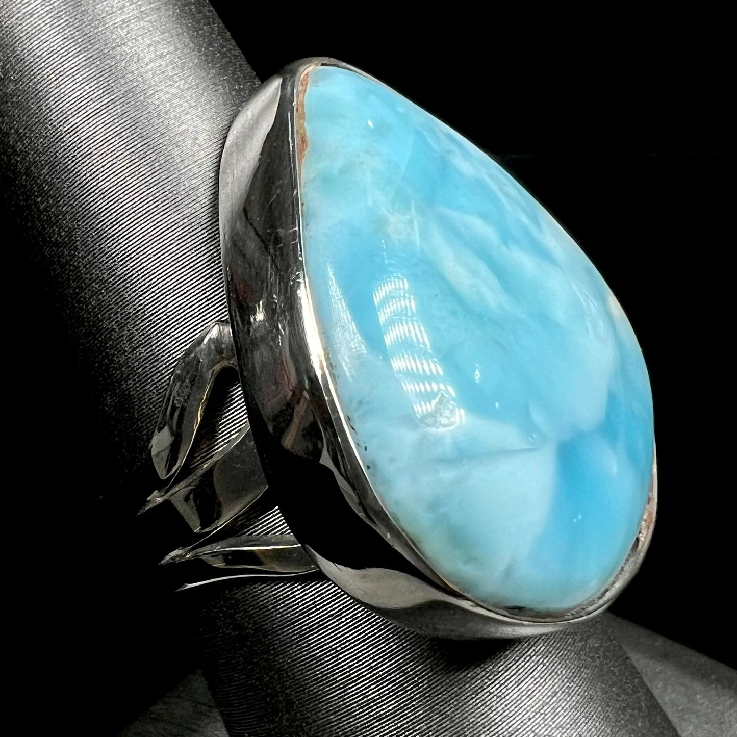 A ladies' large, pear shaped larimar solitaire ring in sterling silver. The larimar stone measures an inch long.