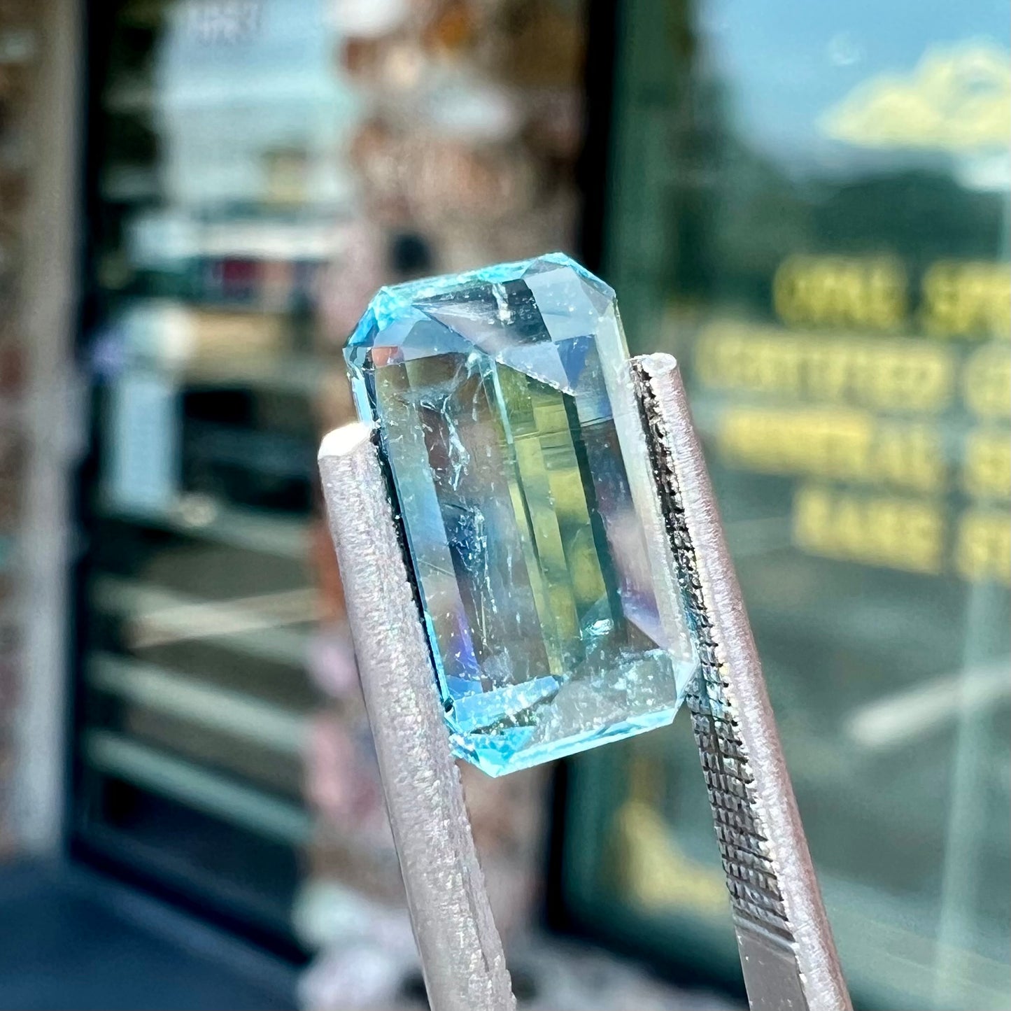 A loose, faceted emerald cut aquamarine stone. The stone is icy blue in color, indicative of Vietnamese origin.