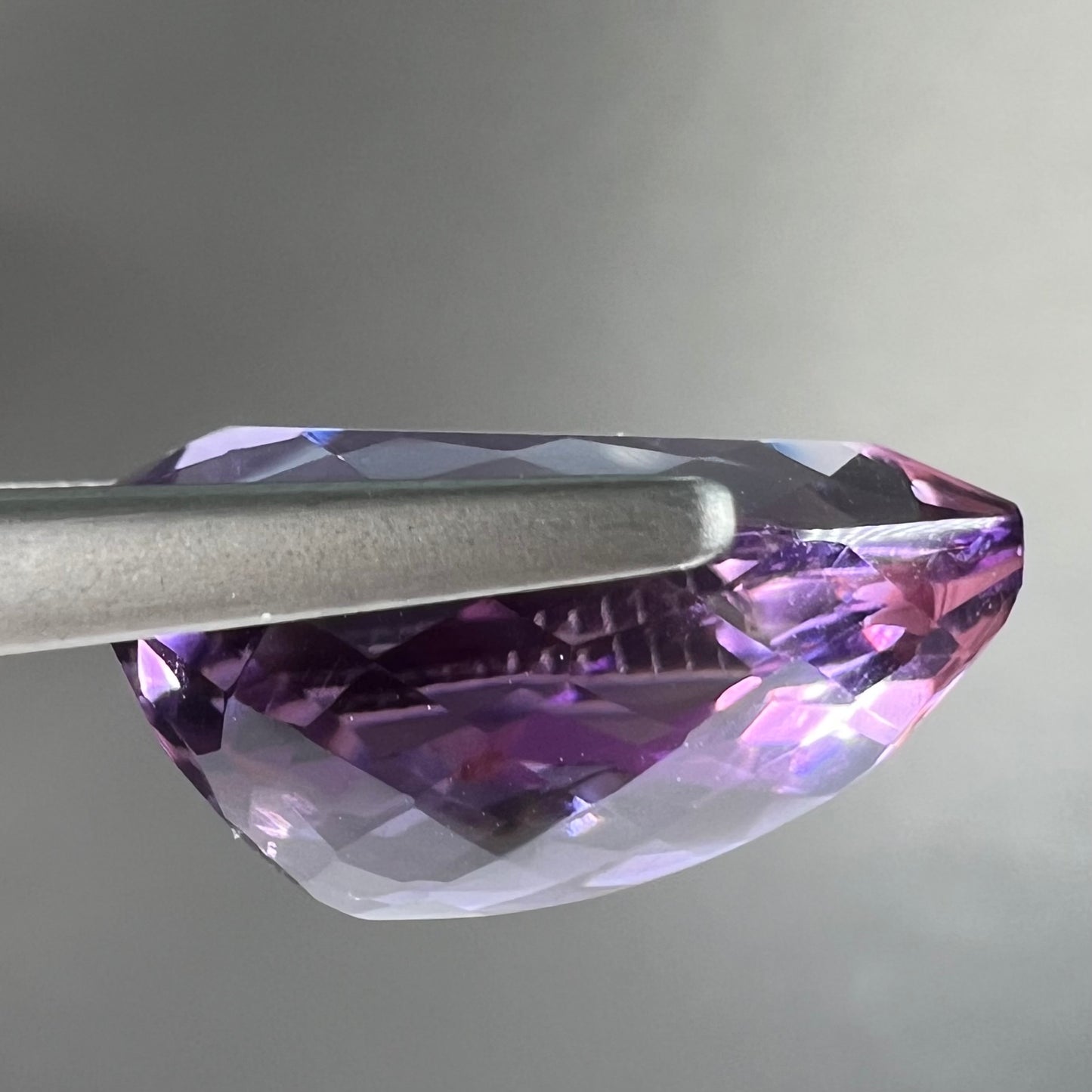 A loose, pear shaped amethyst gemstone. The stone is a medium purple color.