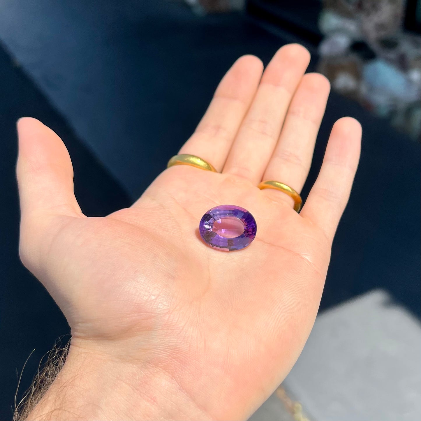 A loose, modified oval cut amethyst gemstone. The stone is a large size.