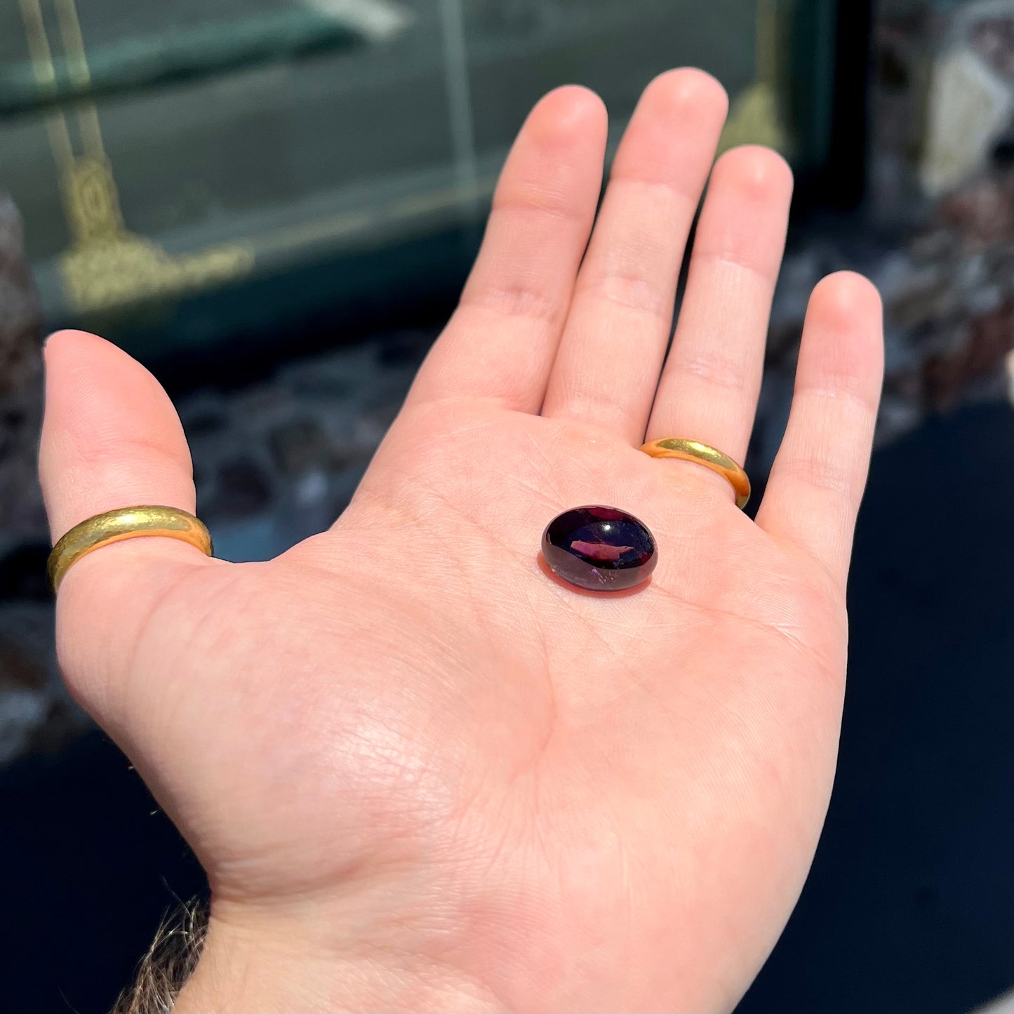 A loose, oval buff top cut amethyst gemstone. The top of the stone is domed, and the bottom is faceted.