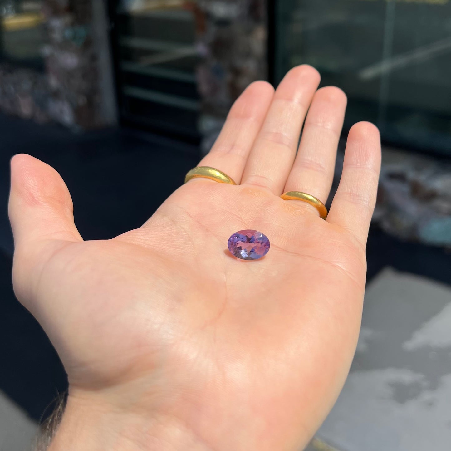 A faceted oval cut amethyst gemstone. The stone is a light purple color.