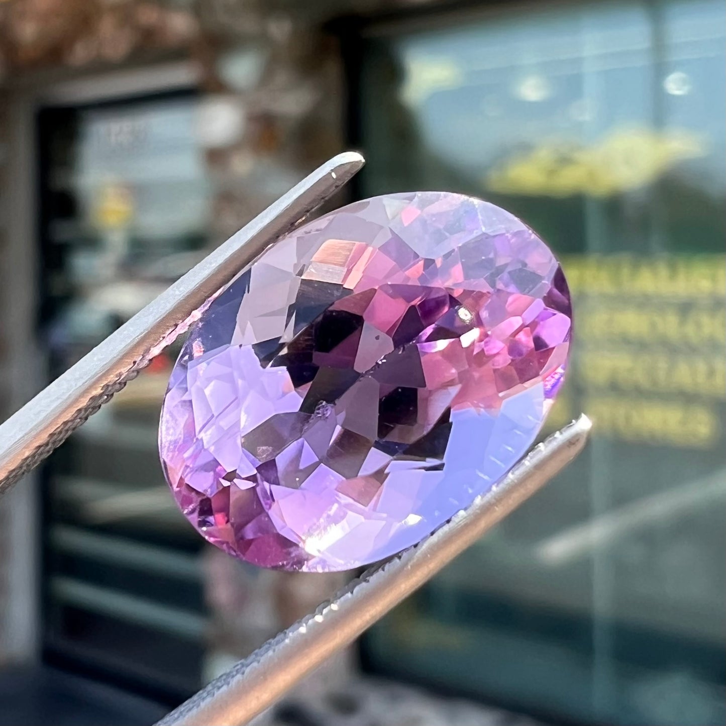 A faceted oval cut amethyst gemstone. The stone is a light purple color.