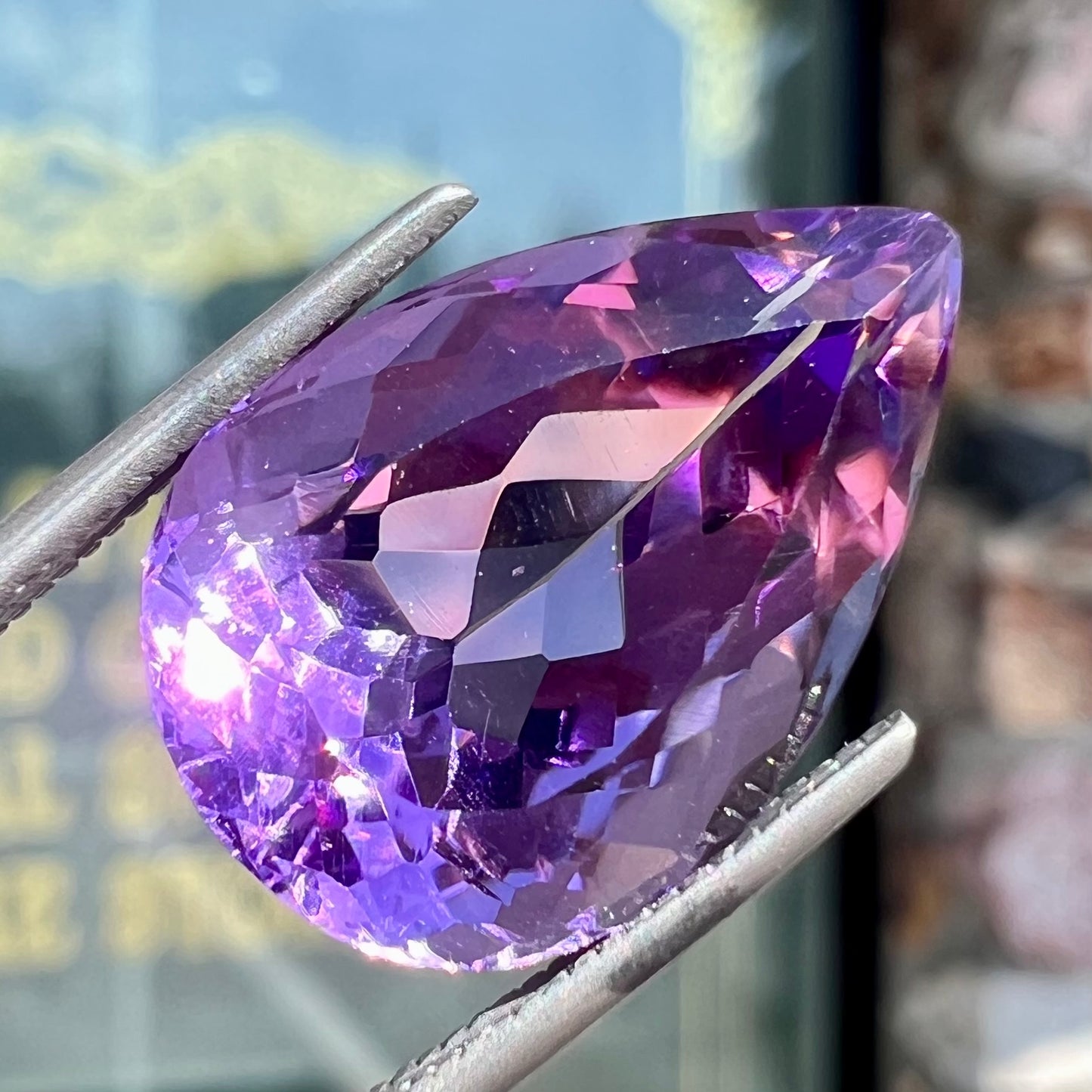A loose, pear shaped amethyst gemstone. The stone is a medium purple color.