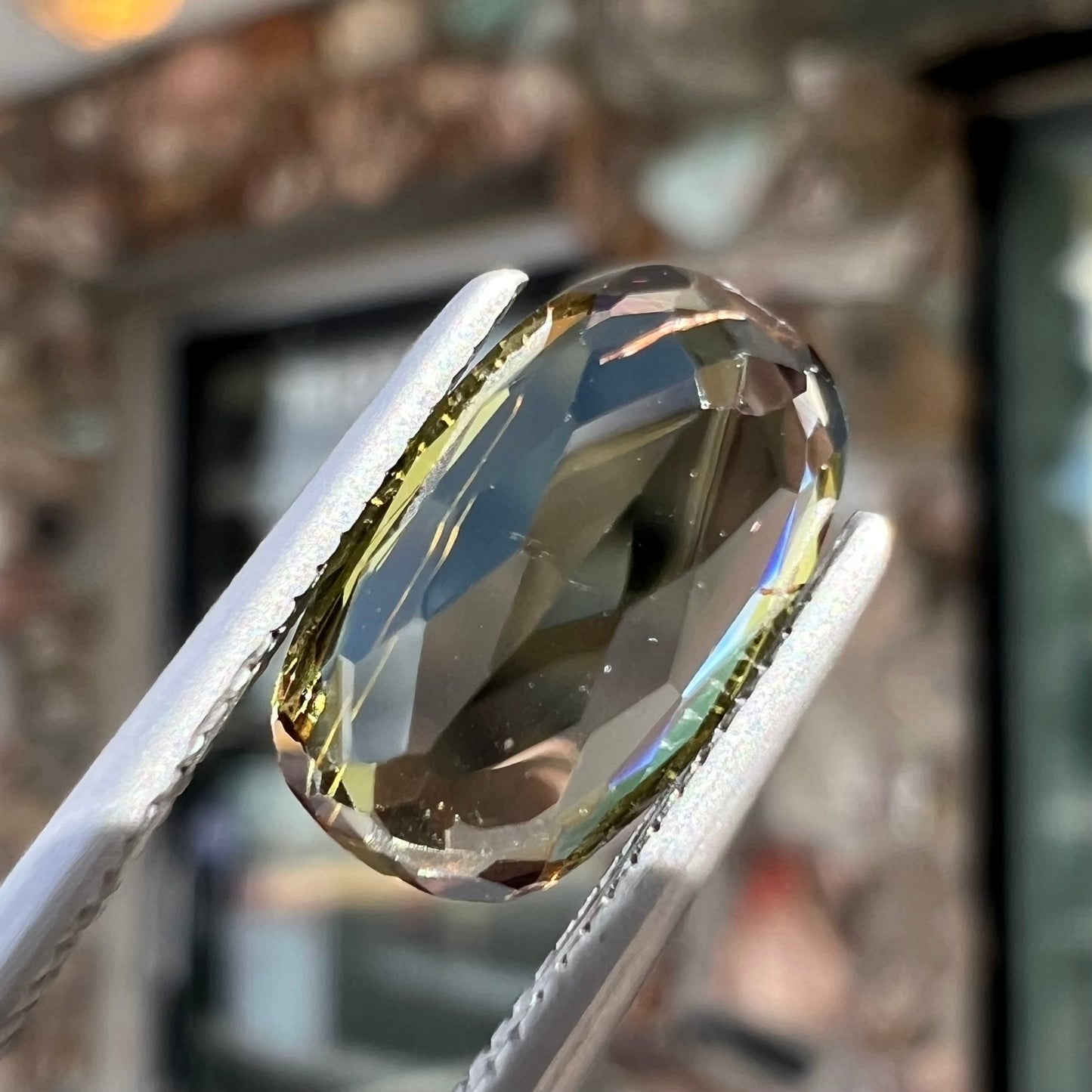 A modified oval cut andalusite gemstone. The stone has eye-visible rutile inclusions.