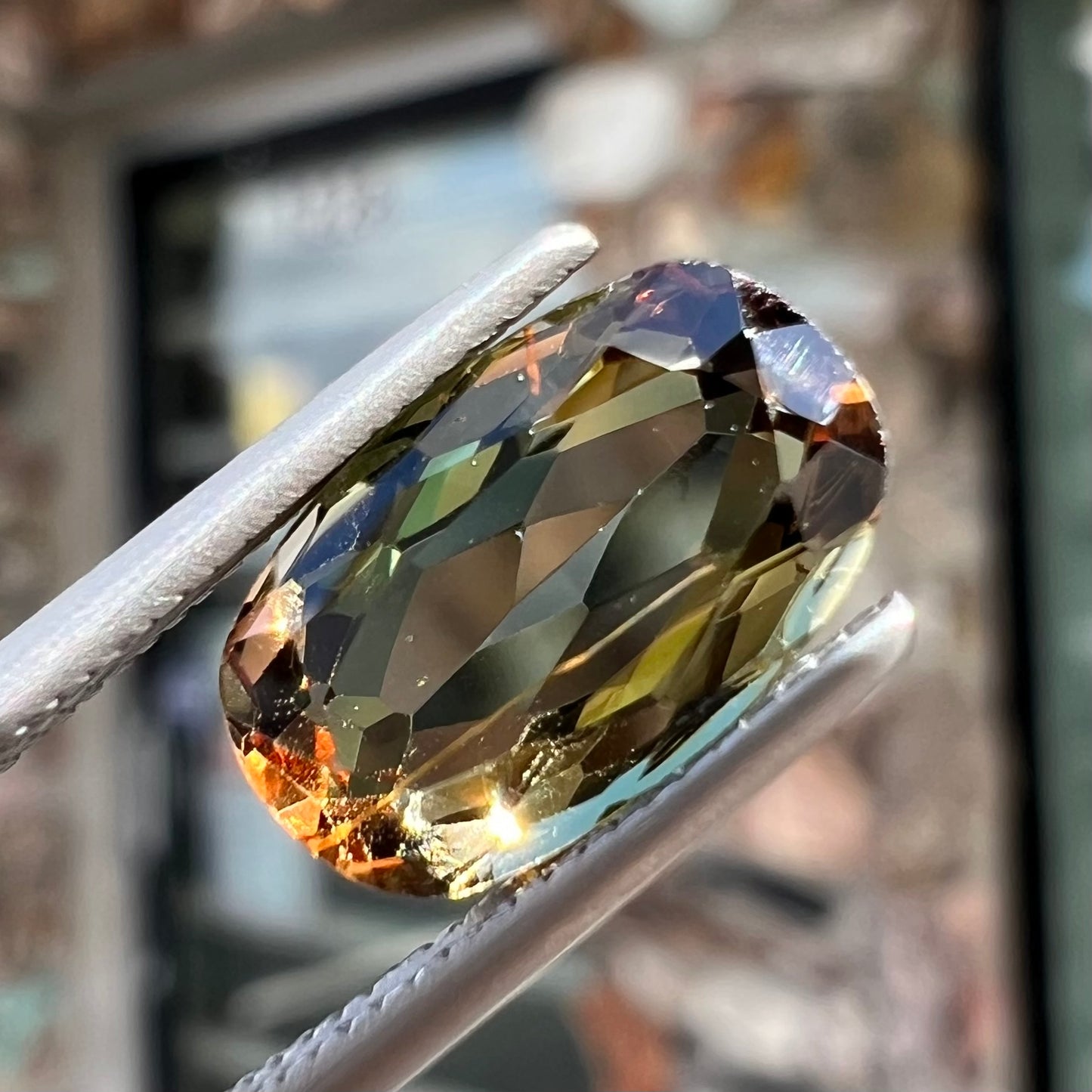 A modified oval cut andalusite gemstone. The stone has eye-visible rutile inclusions.