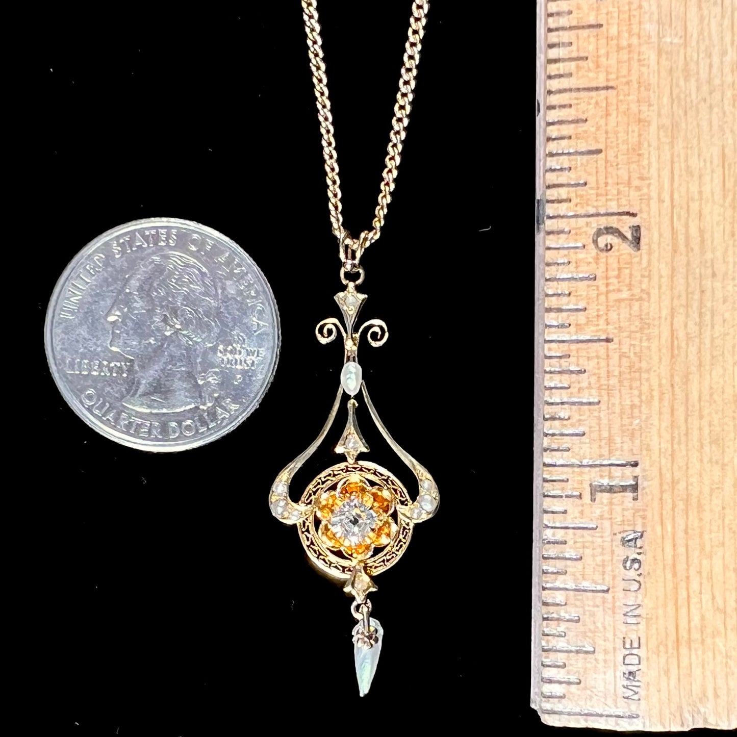 A ladies' Edwardian style gold necklace set with pearls and an old mine cut diamond.  The chain is marked "1916".