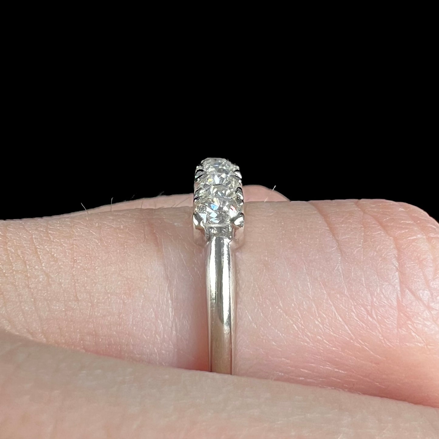 An antique white gold diamond wedding band set with six old mine cut natural diamonds.