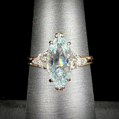A ladies' ring set with a marquise cut aquamarine and round accent diamonds.