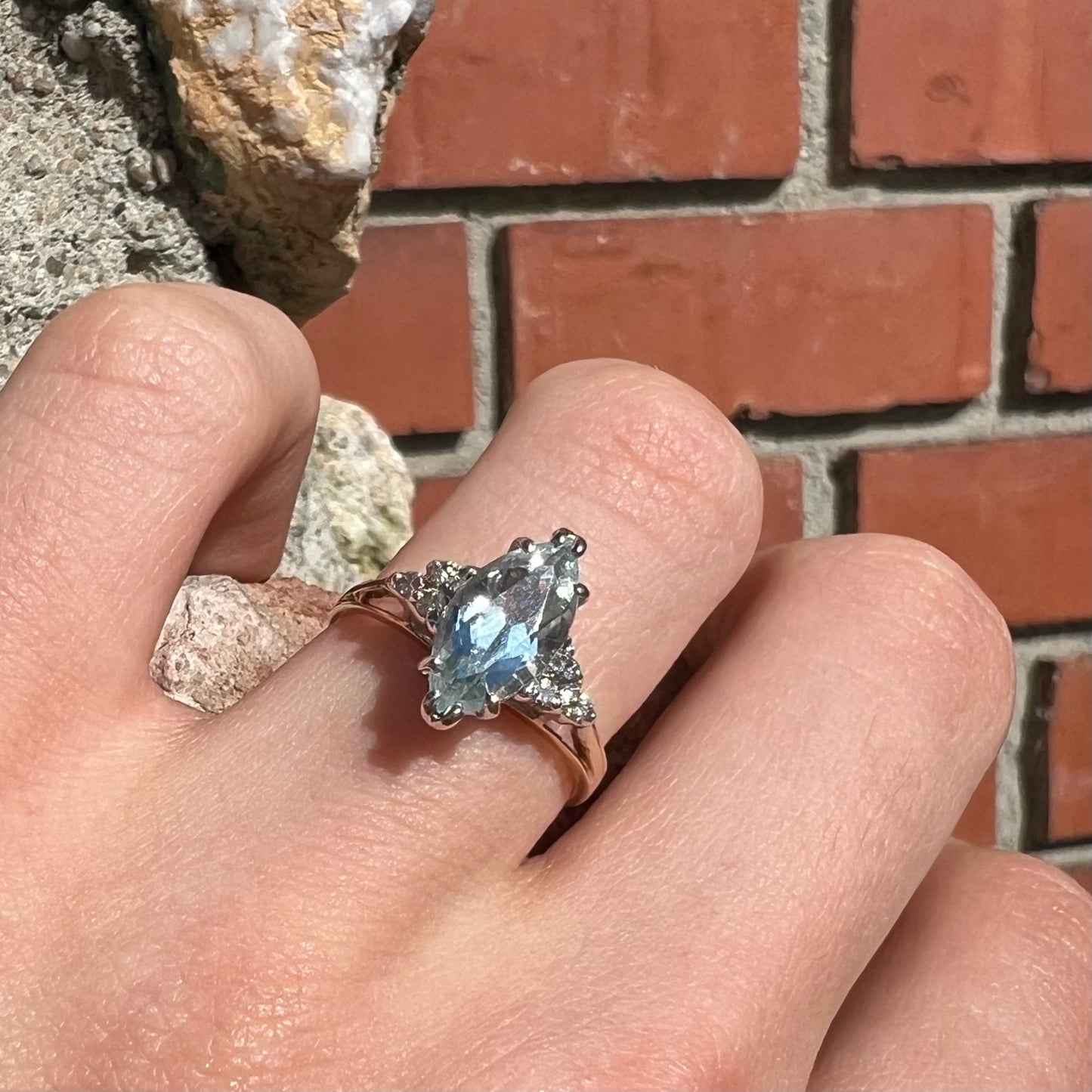 A ladies' ring set with a marquise cut aquamarine and round accent diamonds.