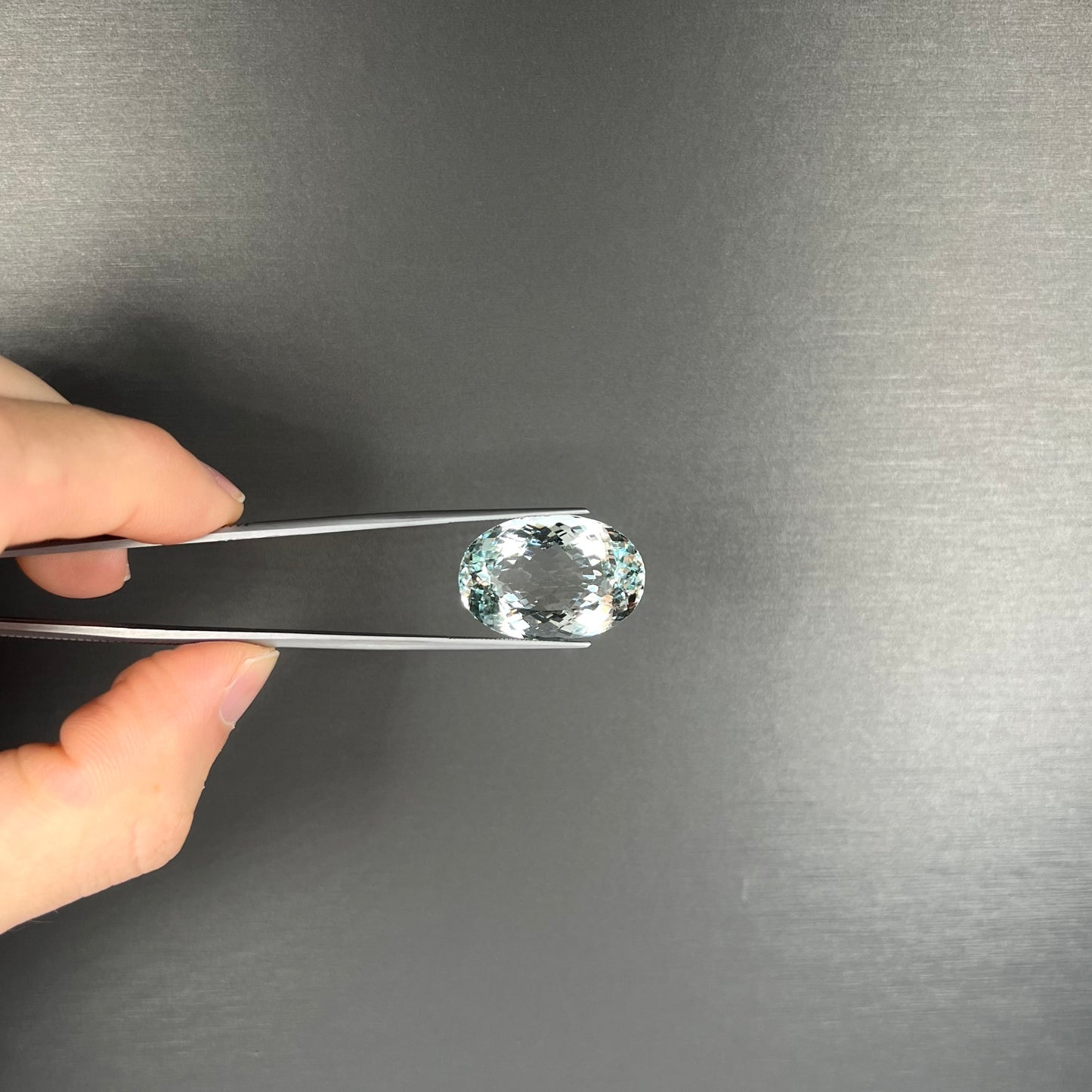 A faceted oval cut Brazilian aquamarine gemstone. The stone is a light blue color.