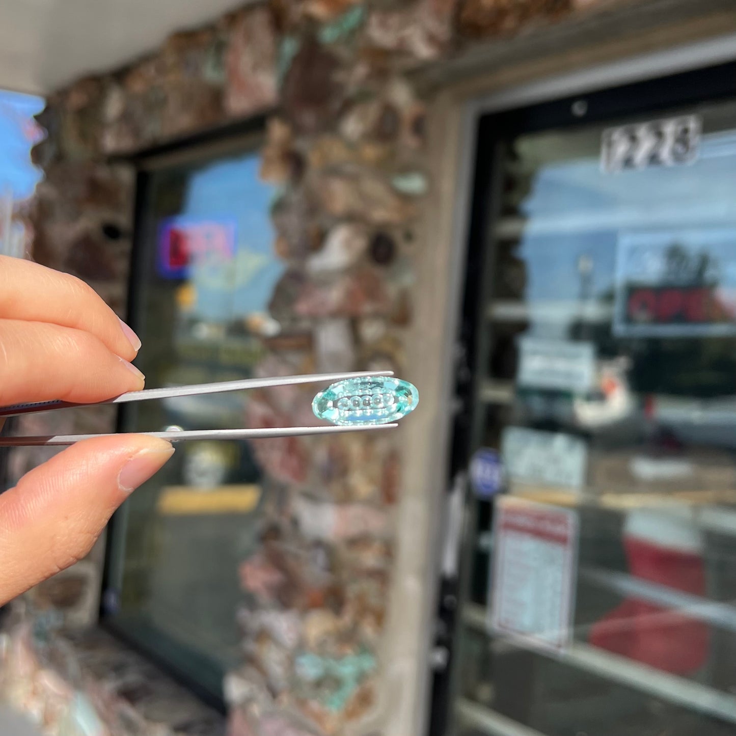 An oval fantasy cut greenish blue aquamarine stone cut by gem carver, Arthur Lee Anderson.
