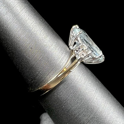 A ladies' ring set with a marquise cut aquamarine and round accent diamonds.