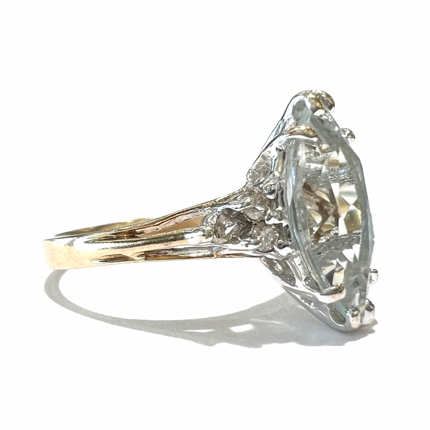 A ladies' ring set with a marquise cut aquamarine and round accent diamonds.