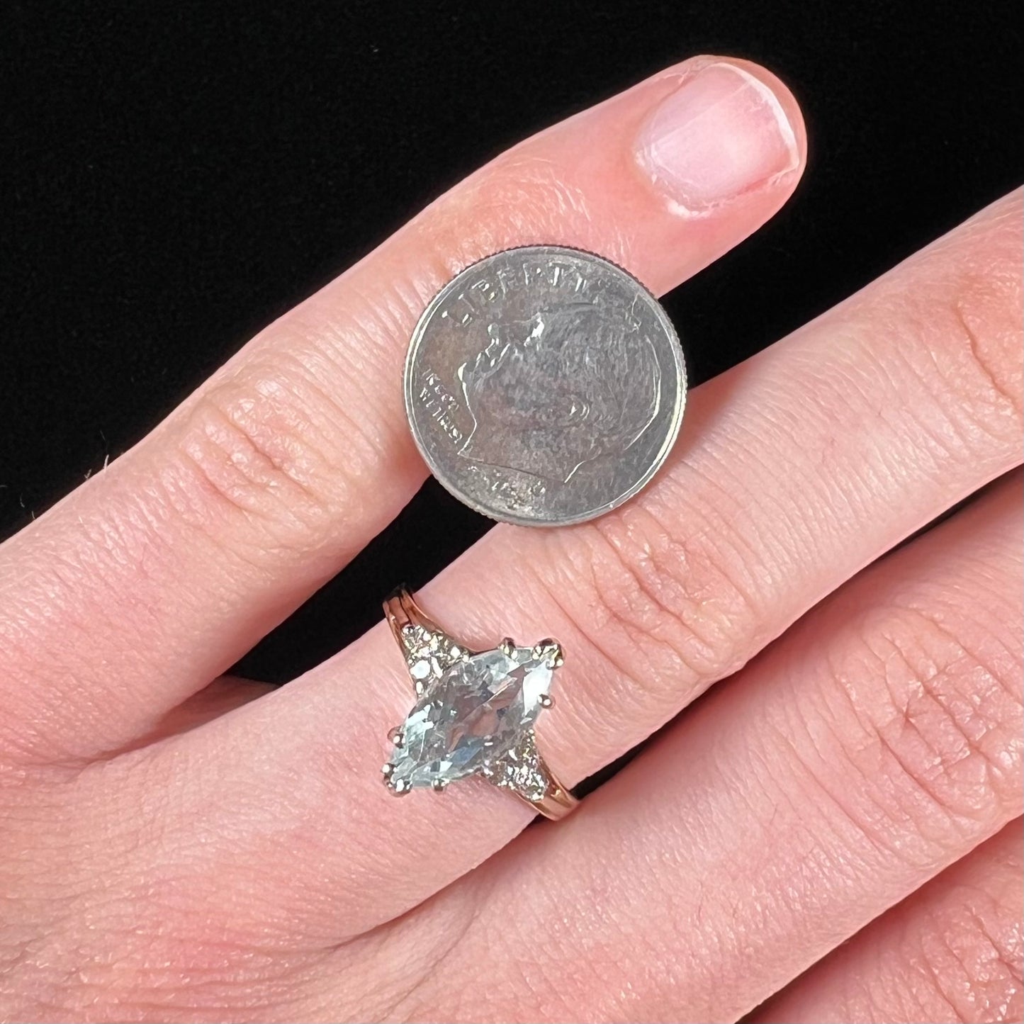 A ladies' ring set with a marquise cut aquamarine and round accent diamonds.