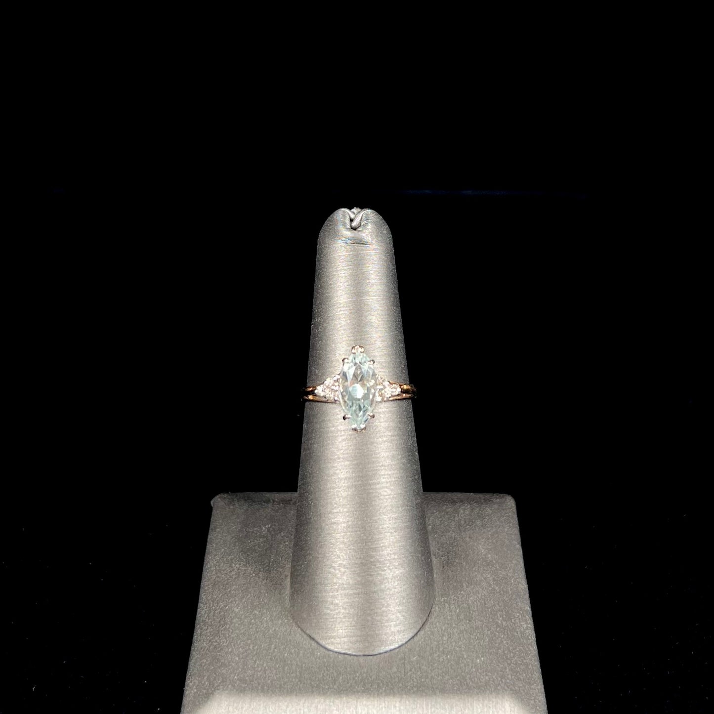 A ladies' ring set with a marquise cut aquamarine and round accent diamonds.