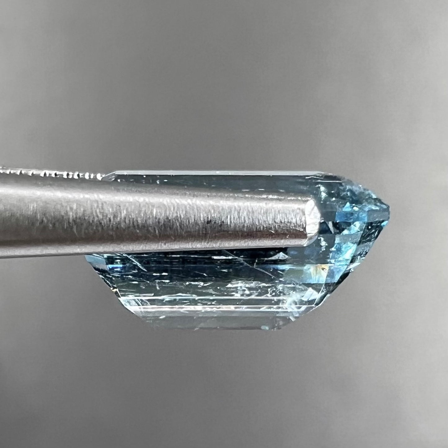 A loose, faceted emerald cut aquamarine stone. The stone is icy blue in color, indicative of Vietnamese origin.