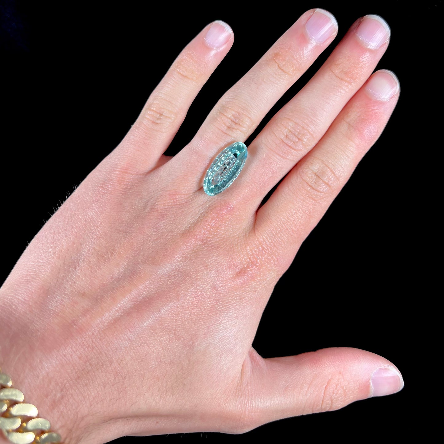An oval fantasy cut greenish blue aquamarine stone cut by gem carver, Arthur Lee Anderson.
