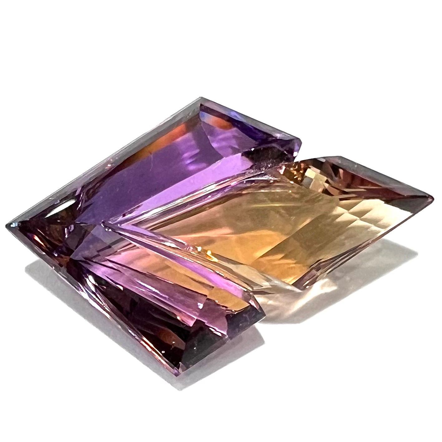 A loose, faceted fantasy cut ametrine gemstone cut by famous carver, Arthur Lee Anderson.