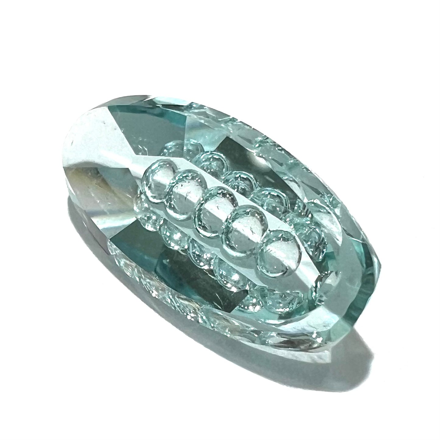 An oval fantasy cut greenish blue aquamarine stone cut by gem carver, Arthur Lee Anderson.