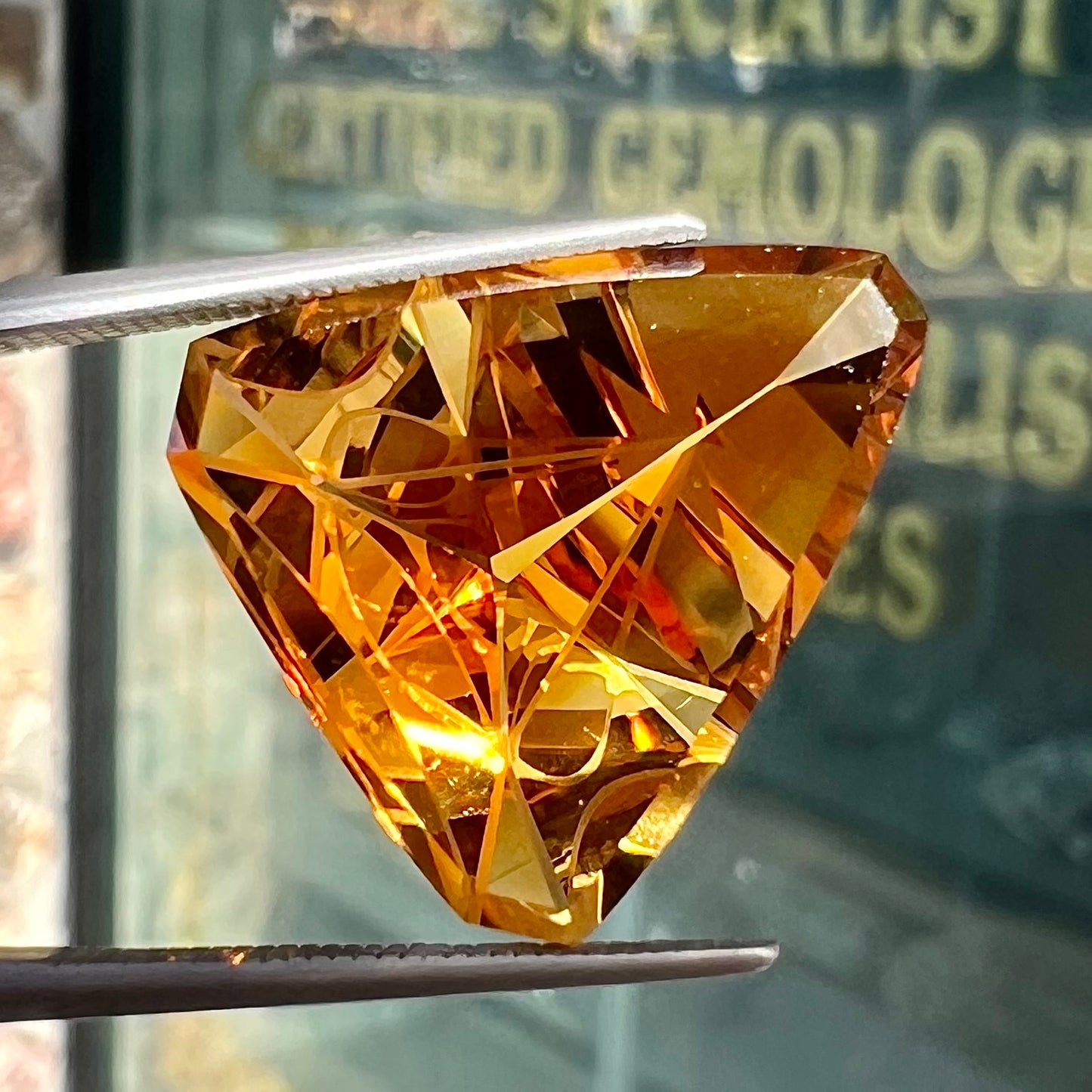 A loose, triangular fantasy cut yellow citrine stone cut by Arthur Lee Anderson.