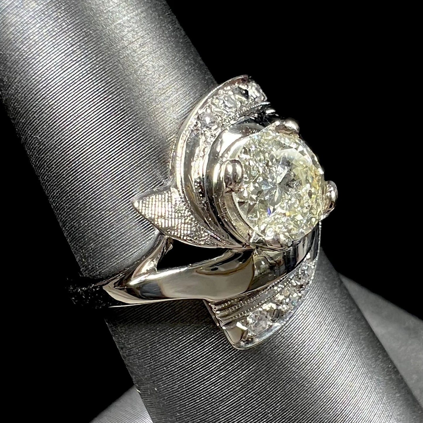 A vintage, Art Nouveau style diamond engagment ring. The ring is white gold with a yellowish, M colored, 1.24 carat diamond.