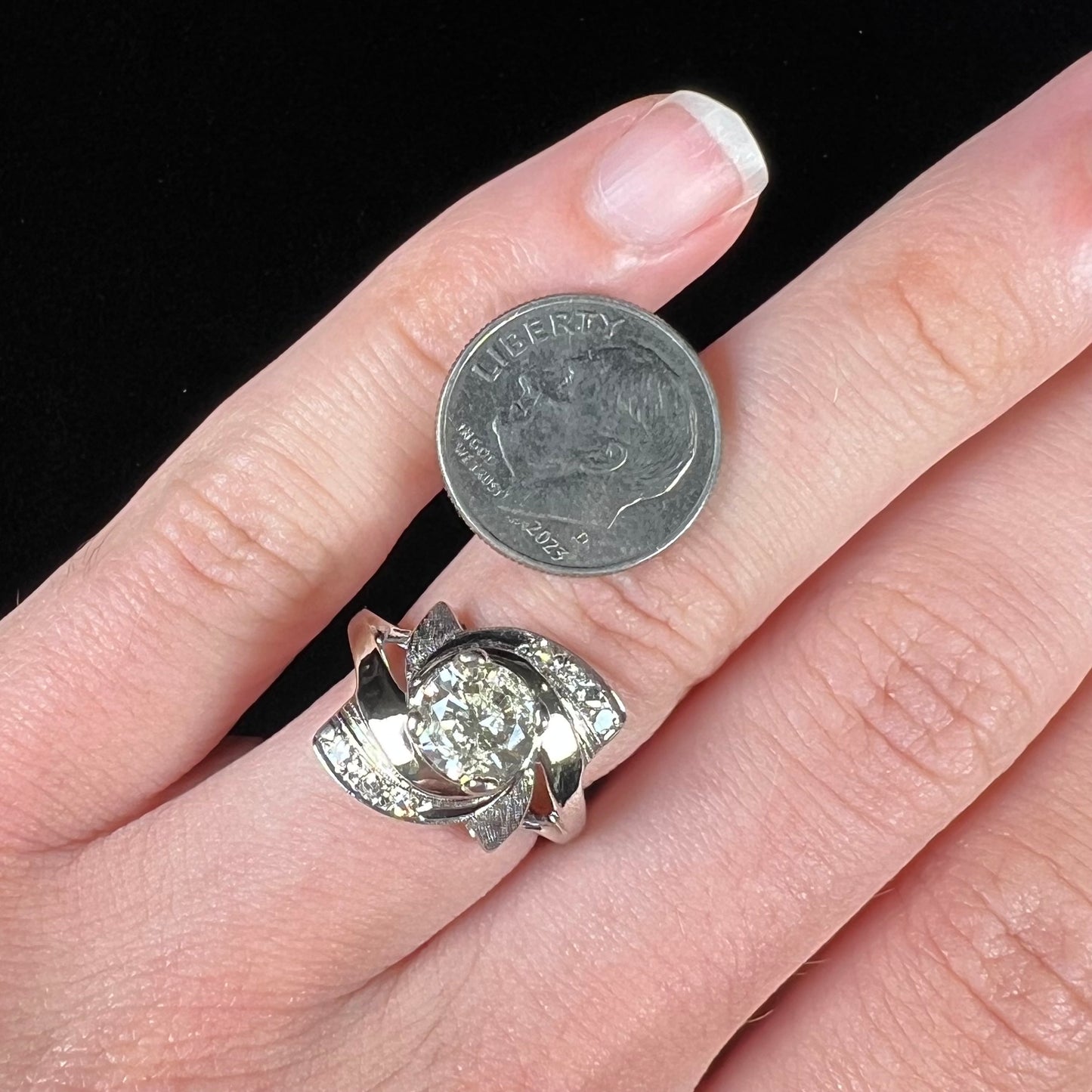 A vintage, Art Nouveau style diamond engagment ring. The ring is white gold with a yellowish, M colored, 1.24 carat diamond.