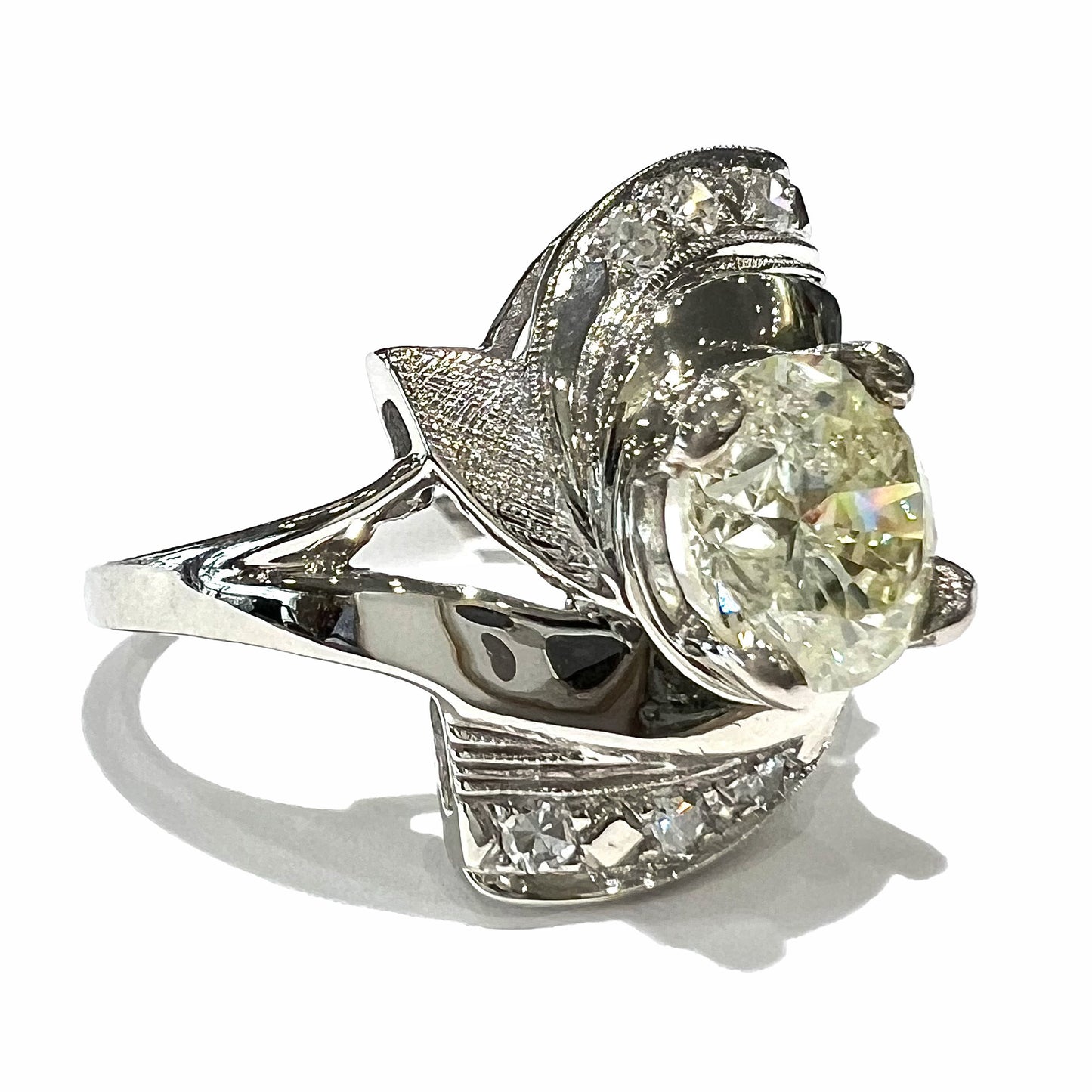 A vintage, Art Nouveau style diamond engagment ring. The ring is white gold with a yellowish, M colored, 1.24 carat diamond.