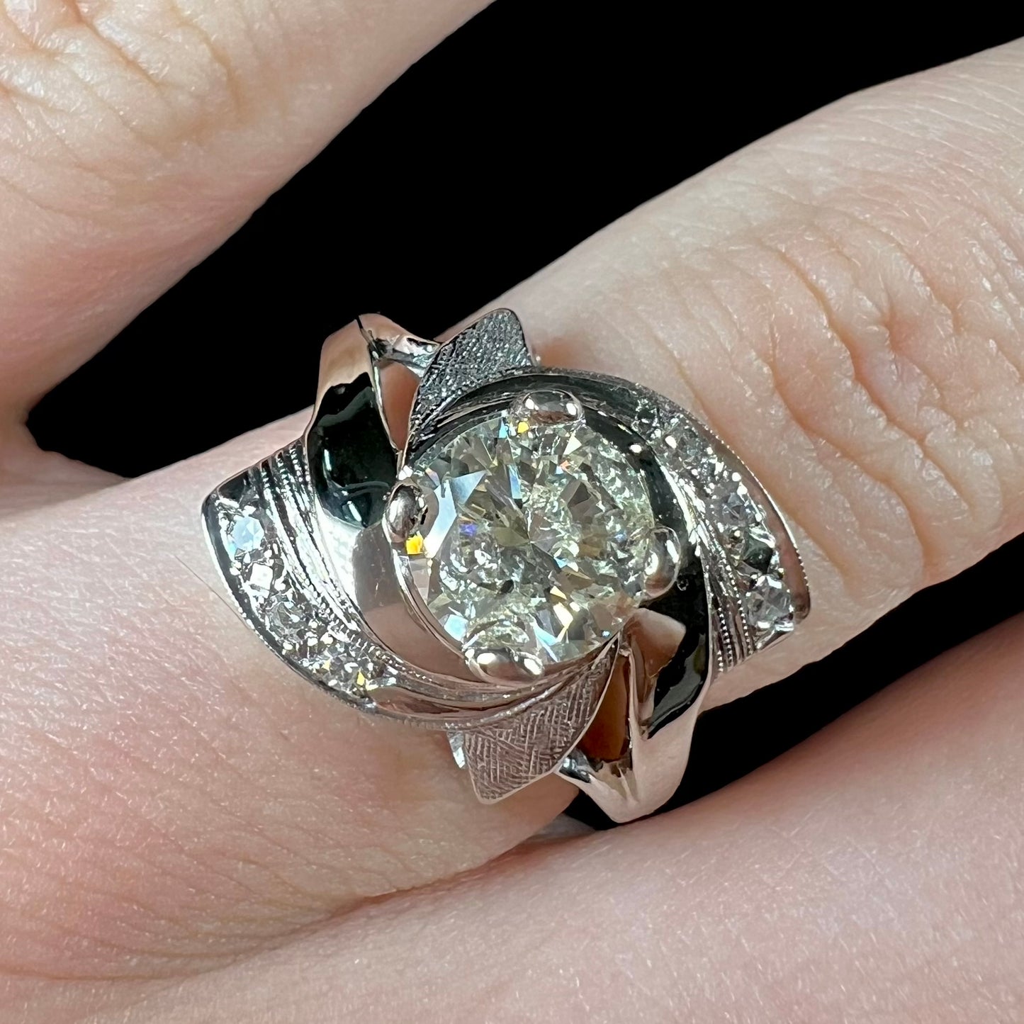 A vintage, Art Nouveau style diamond engagment ring.  The ring is white gold with a yellowish, M colored, 1.24 carat diamond.