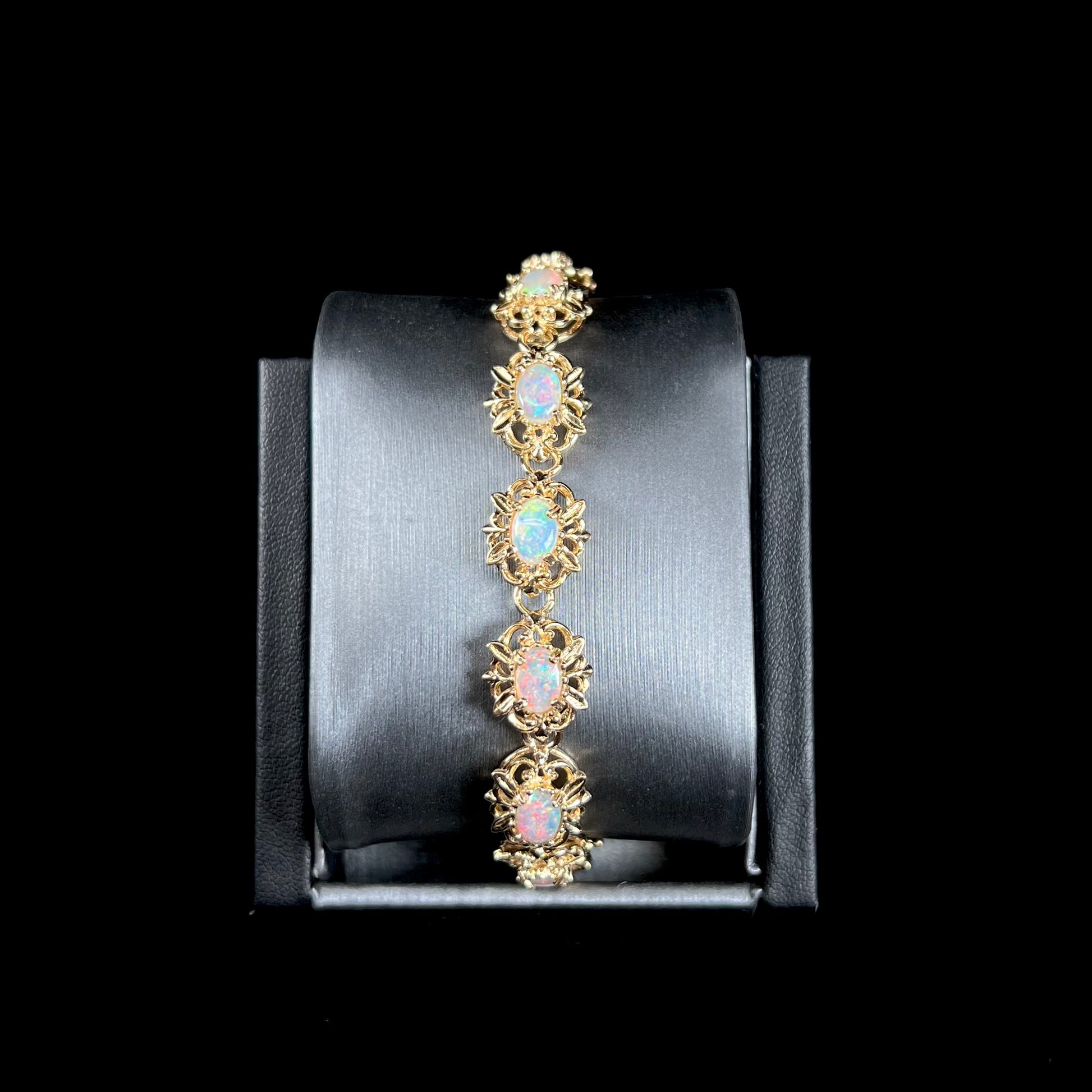 A ladies' yellow gold bracelet set with natural, oval cabochon cut white crystal opals.