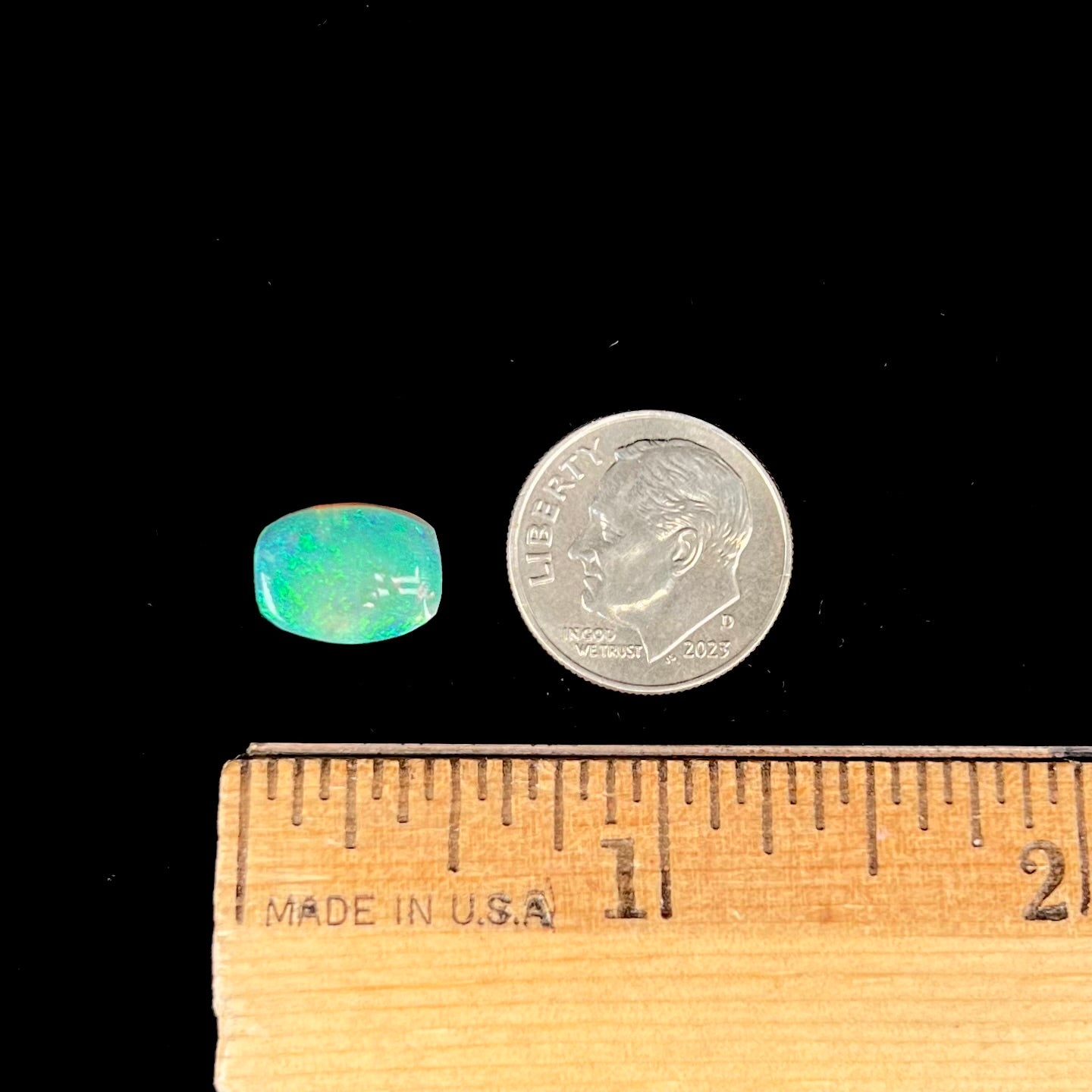 A 2.40ct barrel shaped Lightning Ridge semi-crystal opal. The stone has blue and green colors.