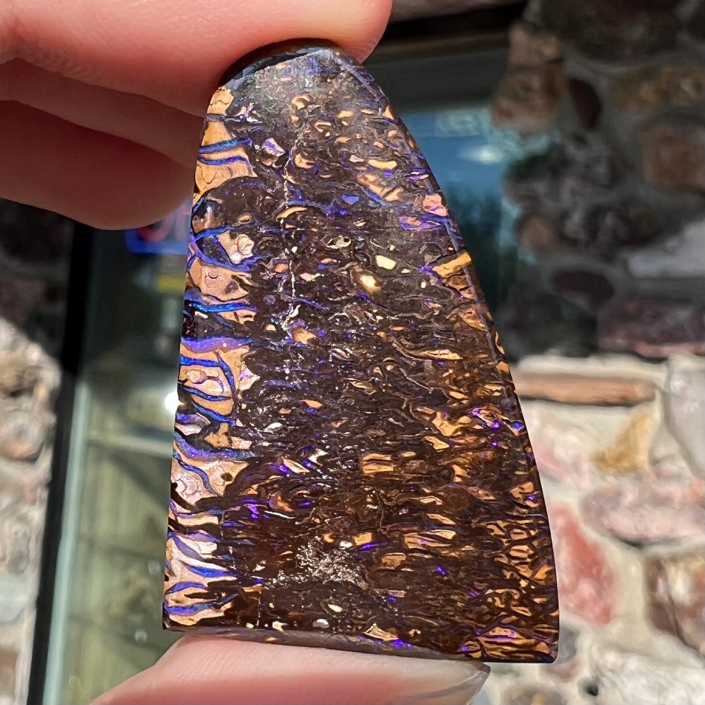 A loose boulder opal stone from Koroit, Australia. The opal has a blue and purple pattern.