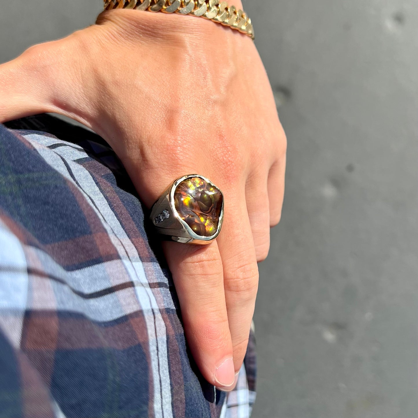 A men's heavy yellow gold ring set with a Mexican fire agate stone and three round brilliant cut diamond accents.