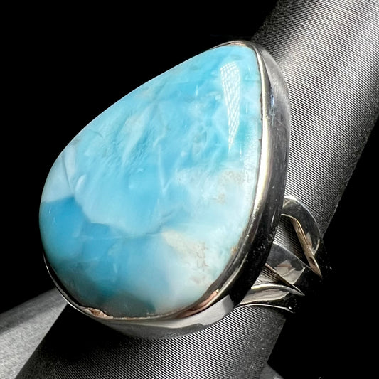 A ladies' large, pear shaped larimar solitaire ring in sterling silver.  The larimar stone measures an inch long.