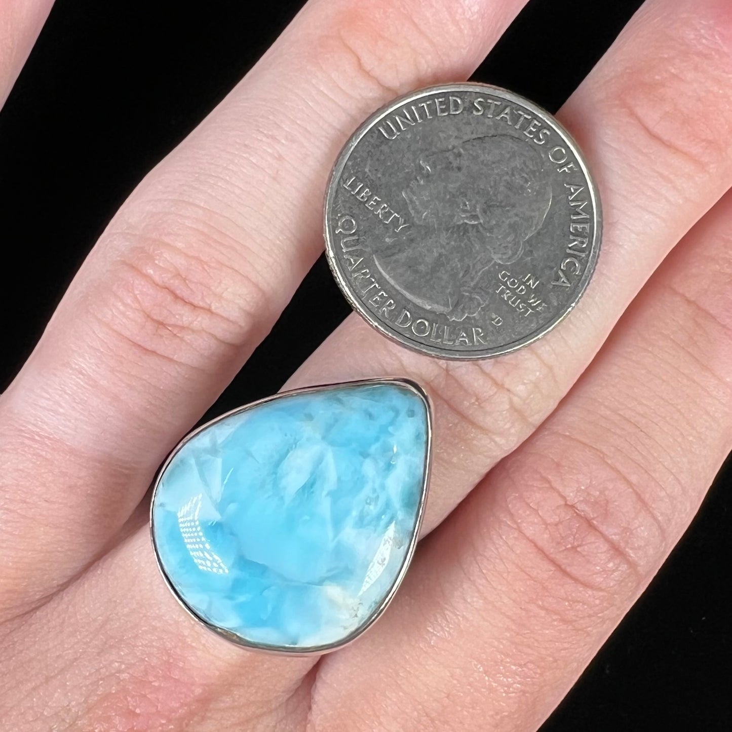 A ladies' large, pear shaped larimar solitaire ring in sterling silver. The larimar stone measures an inch long.