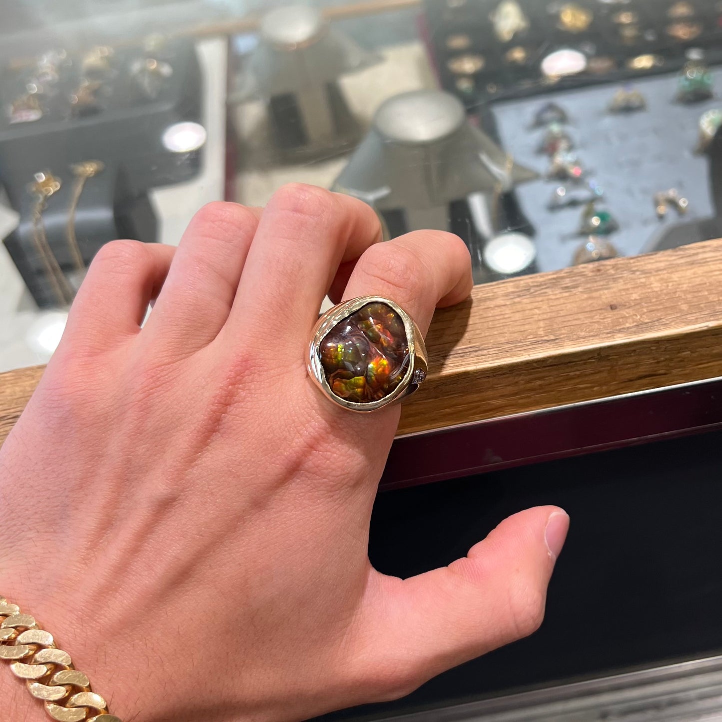 A men's heavy yellow gold ring set with a Mexican fire agate stone and three round brilliant cut diamond accents.