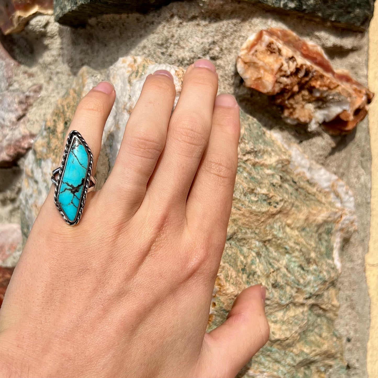A vintage, Southwest style sterling silver ring set with a natural turquoise stone. The stone is blue with a black matrix.