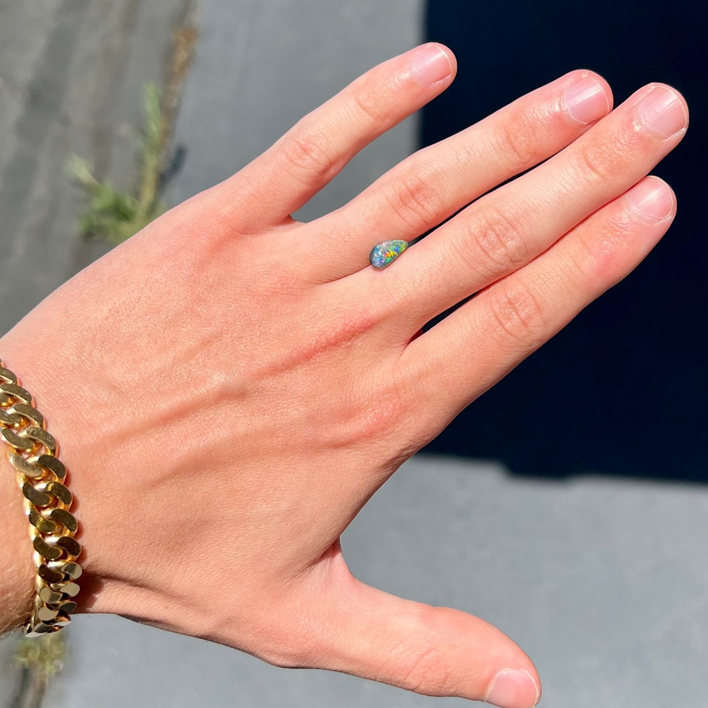 A black opal gemstone from Lightning Ridge, Australia. The opal is a freeform cut.