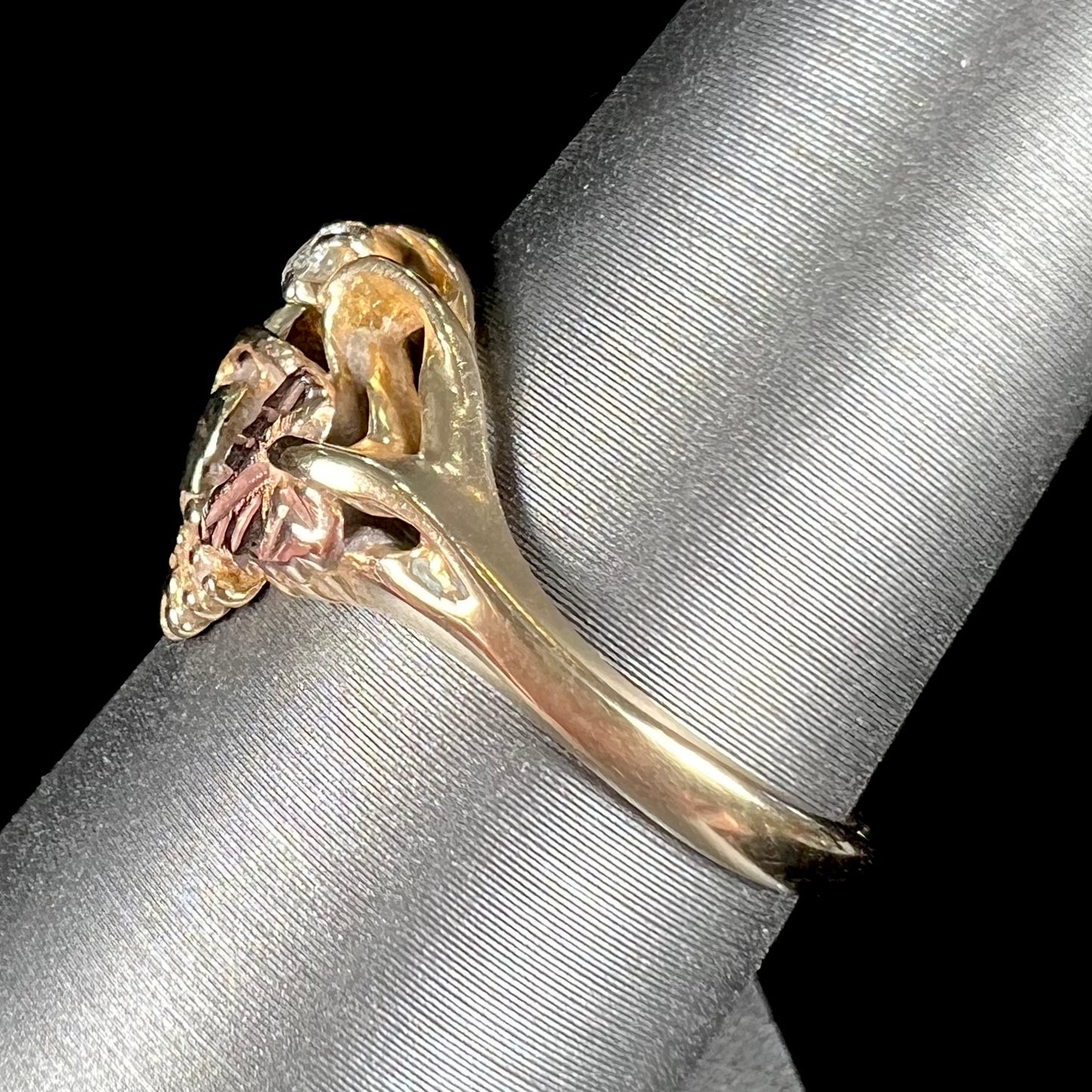 A ladies' two tone rose and yellow gold Black Hills gold diamond ring.  The ring exhibits a leaf design.