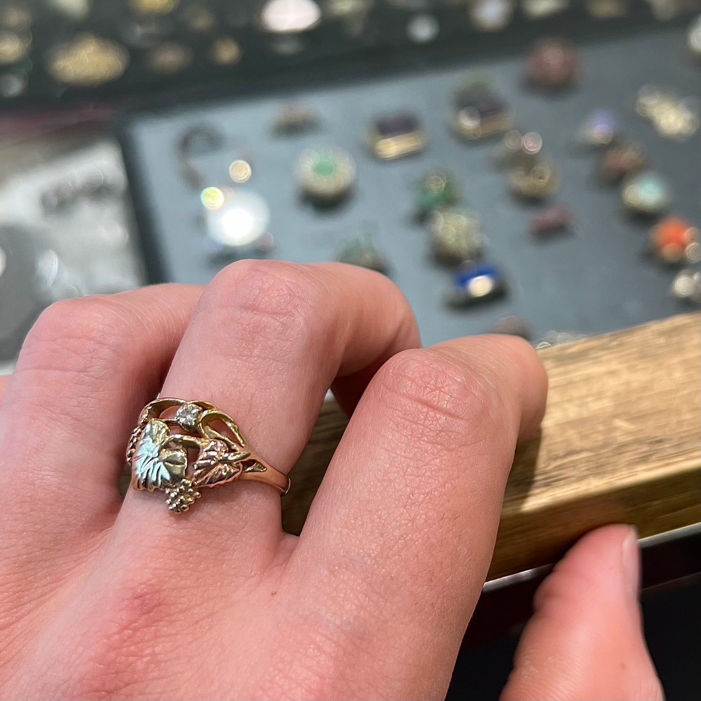 A ladies' two tone rose and yellow gold Black Hills gold diamond ring.  The ring exhibits a leaf design.